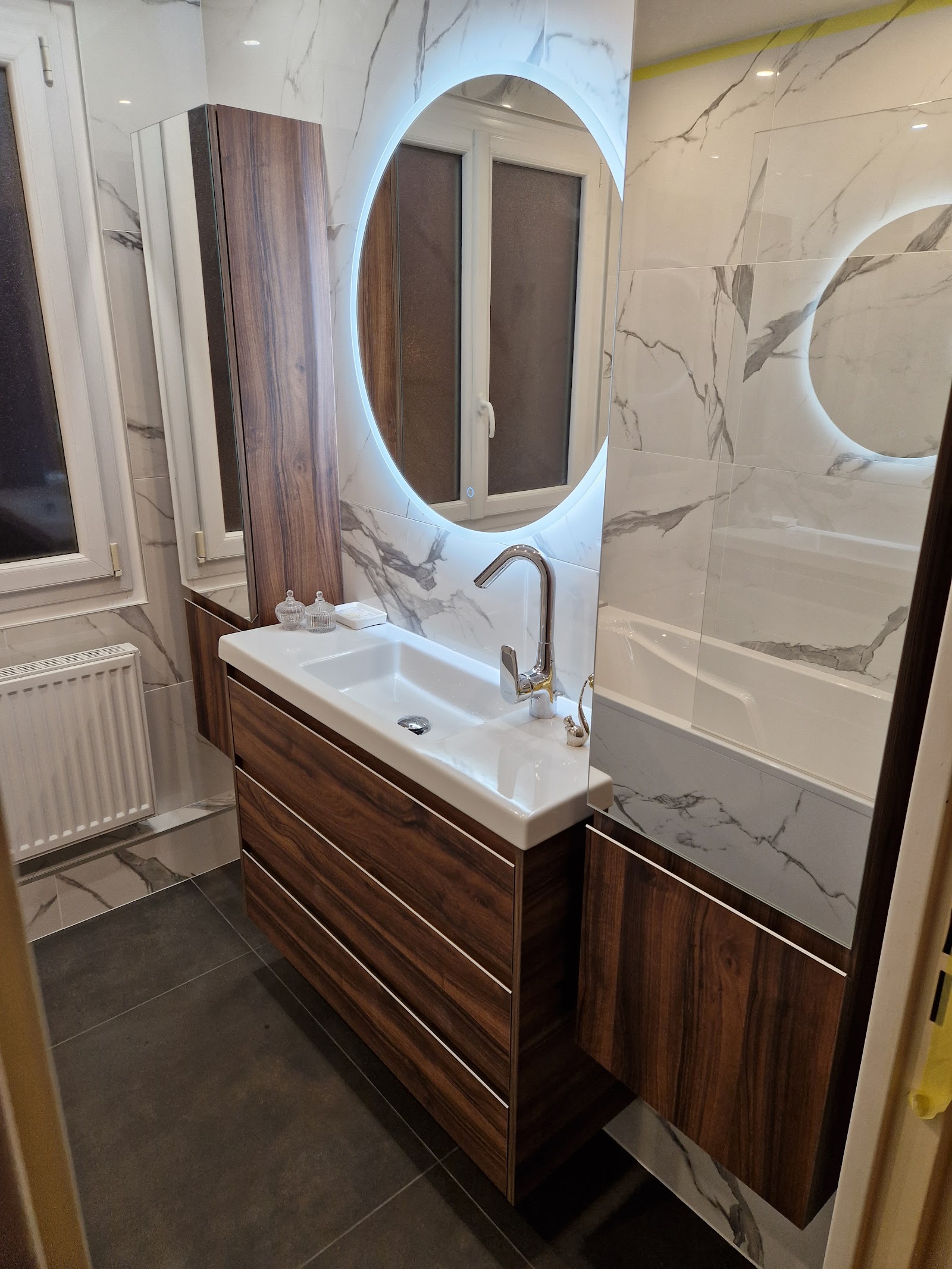 Meuble vasque suspendu et miroir rétro-éclairé dans une salle d'eau design.